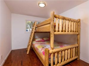 Un dormitorio con una litera en una habitación. en Cozy Escape, Kawarthas Cottage With Sauna, en Buckhorn