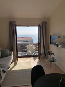奧帕蒂亞的住宿－Opatija Apartment - Ocean Suite & Sea Breeze，带沙发的客厅和带桌子的阳台。