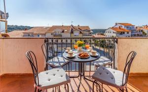 una mesa y sillas en un balcón con vistas en Apartment Green Pula, Family friendly, Comfortable, free parking and WiFi, en Pula