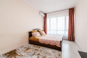 sypialnia z łóżkiem i dużym oknem w obiekcie Element, 157 w mieście Ałma-Ata