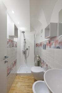 een witte badkamer met 2 toiletten en een douche bij Casa di Nicola - Sciacca in Sciacca