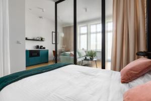 a bedroom with a large bed and a living room at Apartament Aleja 22 in Poznań