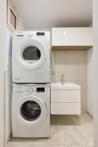 een wasmachine en droger in een badkamer met een wastafel bij Casa di Nicola - Sciacca in Sciacca