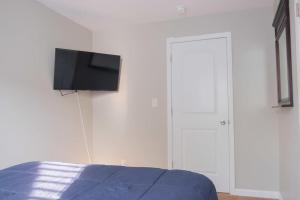 een slaapkamer met een bed en een tv aan de muur bij New 4 Bedroom House for Downtown Travelers!!! in Indianapolis