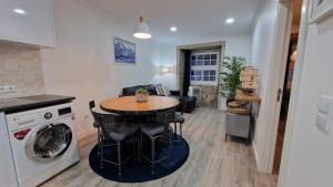 a kitchen and living room with a table and a washing machine at Merc Porto Ribeira's View in Porto