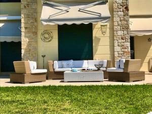 a patio with a couch and chairs and an umbrella at Aegean Pearl in Possidi