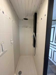y baño con ducha a ras de suelo y azulejos blancos. en LE SOULAQUET, en Soulages-Bonneval