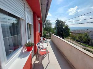 een balkon met 2 stoelen, een tafel en een raam bij Sobe Zimmer Rooms in Bileća