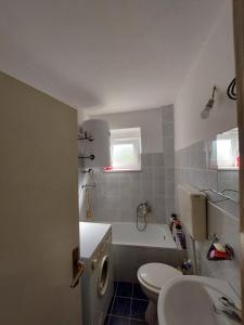 een badkamer met een bad, een toilet en een wastafel bij Sobe Zimmer Rooms in Bileća
