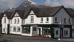 a large white building with a mountain in the background at Highland Getaway in Kinlochleven