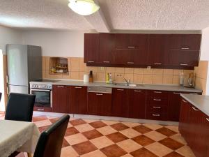 a kitchen with wooden cabinets and a checkered floor at Vila Reževići in Budva