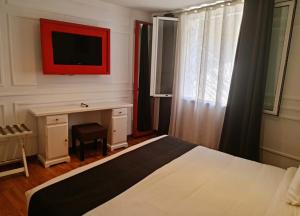 - une chambre avec un lit, un bureau et une télévision dans l'établissement Le Cocooning 974 Hôtel Restaurant Réunion, à Antananarivo