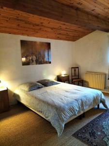 1 dormitorio con cama y techo de madera en la maison sous le château, en Montségur