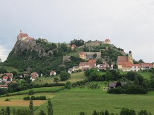 ein Dorf auf einem Hügel mit einem Schloss oben in der Unterkunft Apartmenthaus STYRIA in Bad Gleichenberg