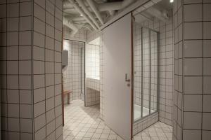 a corridor of a bathroom with white tiles at Generator Amsterdam in Amsterdam