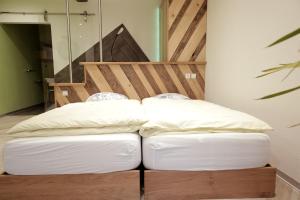 1 cama con 2 almohadas en una habitación en Le Domaine du Verger, Chambres et SPA prive, en Osenbach
