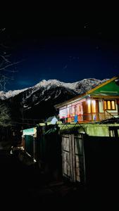 Mir guest house في باهالجام: منزل في الليل مع جبل في الخلفية