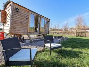 a tiny house with two chairs in the yard at Cariad Bach in Rhyl
