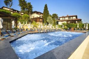a swimming pool with chairs and umbrellas at Eve Santa Marina Apartment II - sea, pools, relax in Sozopol