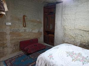- une chambre avec un lit et une chaise dans l'établissement CAVE HOUSE(KIR EVİ), à Ürgüp