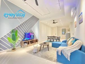 a living room with a blue couch and a tv at OngKimWee Residence By Heystay Management in Melaka
