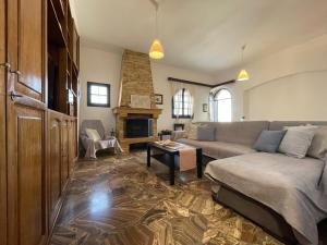 ein Wohnzimmer mit einem Sofa und einem Kamin in der Unterkunft Fyrogenis Cozy Family Friendly House in Gournes in Gournes
