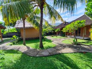 una pasarela frente a una casa con palmeras en Menjangan View, en Banyuwedang