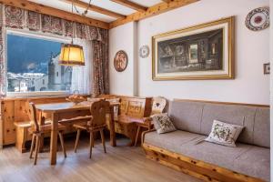 ein Wohnzimmer mit einem Sofa und einem Tisch in der Unterkunft DolomiApartments - Casa Daria in Predazzo