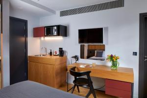 een kleine keuken met een bureau en een wastafel bij London Paddington Apartments in Londen
