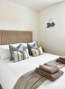 a bedroom with a large white bed with pillows at The Nook - Cosy coastal retreat near Sandbanks in Poole