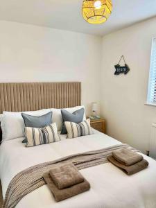 a bedroom with a large bed with two towels on it at The Nook - Cosy coastal retreat near Sandbanks in Poole