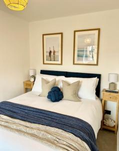 1 dormitorio con 1 cama blanca grande con almohadas en The Nook - Cosy coastal retreat near Sandbanks, en Poole