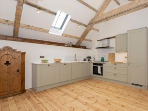 a kitchen with white cabinets and a wooden floor at The Cider Barn in Colebrooke