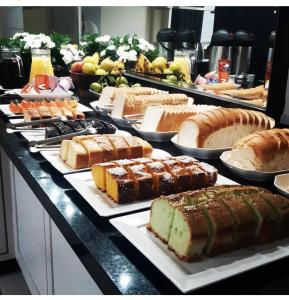 un buffet con muchos tipos diferentes de pasteles y repostería en Hotel Germânia Nova Veneza, en Nova Veneza