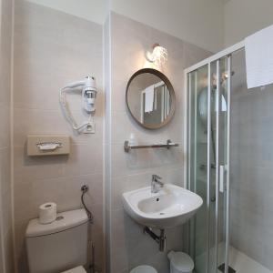 y baño con aseo, lavabo y espejo. en The Originals Access, Hotel Le Canter Saumur en Saumur