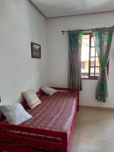 a bedroom with a red bed and a window at Vivendas do Serrano Apart105 Lençois in Lençóis