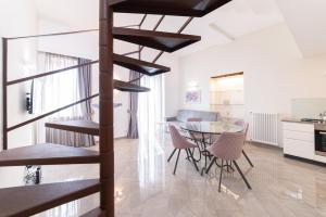 a kitchen and dining room with a spiral staircase in a apartment at Casa Umberto I , Taormina Centro in Taormina
