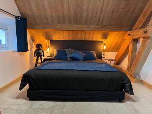 a bedroom with a large bed with a wooden ceiling at Refuges sous les toits in Bourg-Saint-Maurice