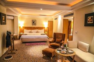 AmeerpetにあるKatriya Hotel and Towerのベッドとリビングルームが備わるホテルルームです。