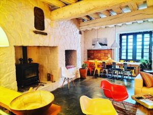 a living room with a fireplace and a table and chairs at la maison sous le château in Montségur