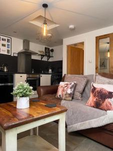 a living room with a couch and a table at Hollies Cottage in Keighley