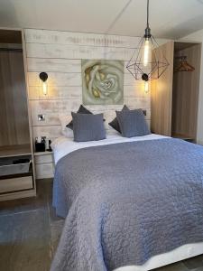 a bedroom with a large bed with blue pillows at Hollies Cottage in Keighley