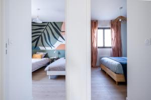 een slaapkamer met 2 bedden en een kamer met een spiegel bij La Perle Villa neuve, proche gare, comédie, et tramway in Montpellier