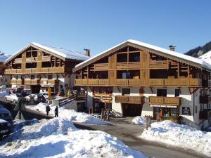 un grande edificio in legno con neve di fronte di Appartement Notre-Dame-de-Bellecombe, 3 pièces, 6 personnes - FR-1-505-151 a Notre-Dame-de-Bellecombe