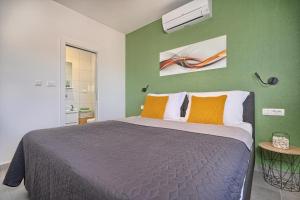 a bedroom with a bed and a green wall at Mare‘s Place - Premium Seaview Apartment in Slatine