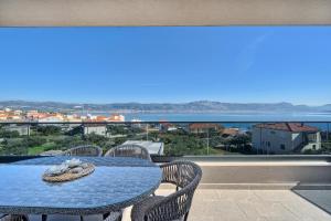 a table on a balcony with a view of the ocean at Mare‘s Place - Premium Seaview Apartment in Slatine