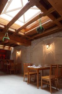 comedor con mesa, sillas y ventana en Hotel ASL, en Bukhara