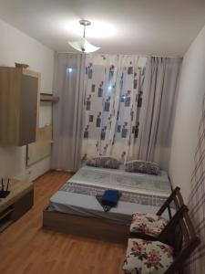 1 dormitorio con 1 cama, 1 silla y TV en Апартмент Паисий 15, en Varna