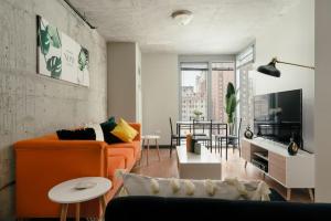 a living room with an orange couch and a table at Affordable 2-Bedroom on Wabash in Chicago