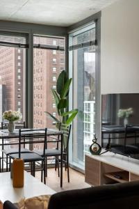 a living room with a table and chairs and windows at Affordable 2-Bedroom on Wabash in Chicago